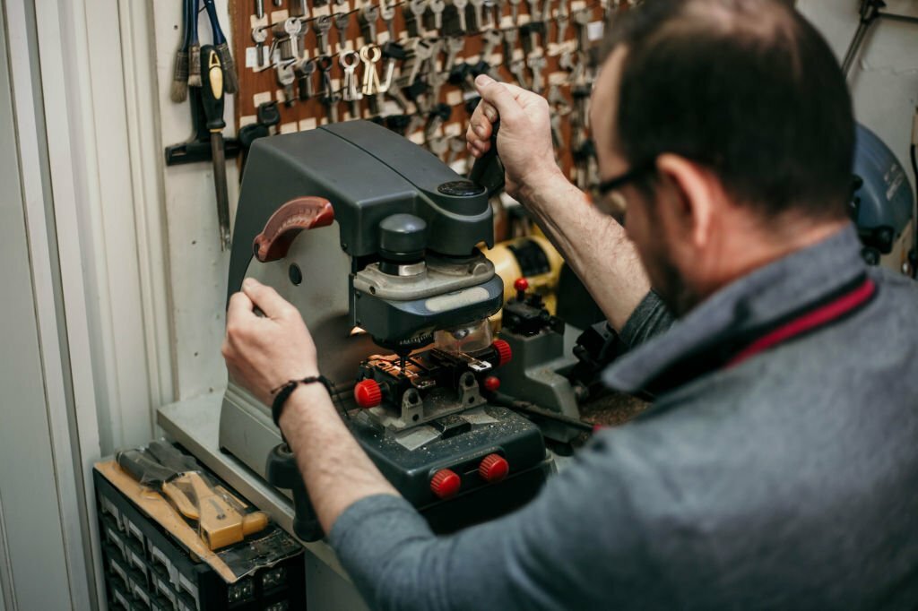 Authentic mature locksmith is duplicating his keys in his small family shop