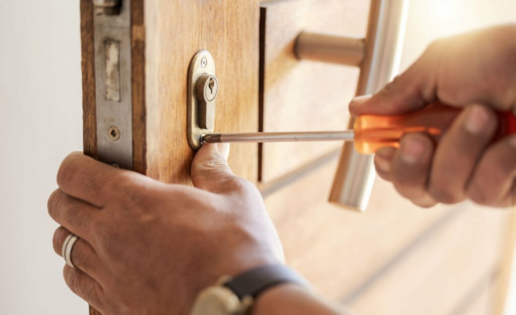 Locksmith hands, maintenance and handyman with tools, home renovation and fixing, change door locks and closeup. Construction, building industry and trade with manual labour, vocation and employee